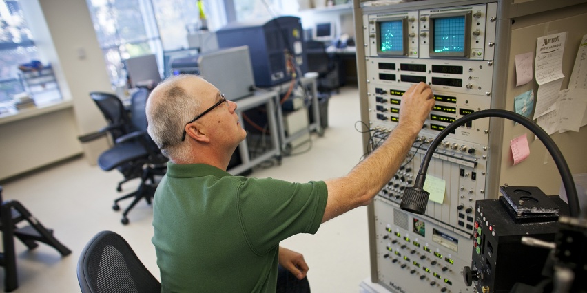 man presses buttons on a large machine